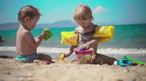 Playing with Sand and Waves on The Beach on a Summer Day Stock Footage 60381939