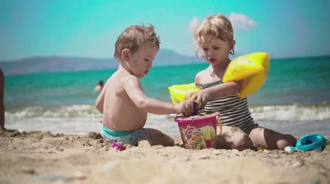 Playing with Sand and Waves on The Beach on a Summer Day Video stock 60382334
