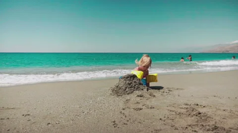 Playing with Sand and Waves on The Beach on a Summer Day Stock Footage 60382882