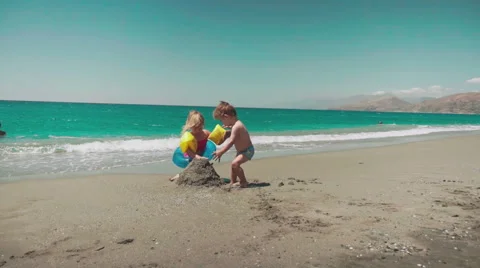 Playing with Sand and Waves on The Beach on a Summer Day 動画素材 60383062