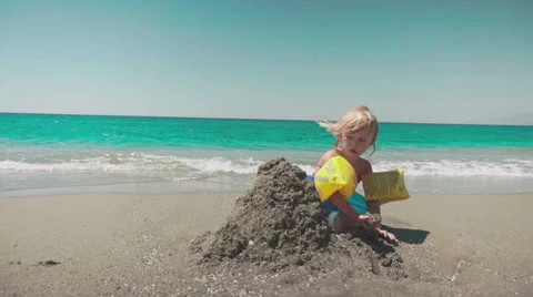 Playing with Sand and Waves on The Beach on a Summer Day Видео 60383542