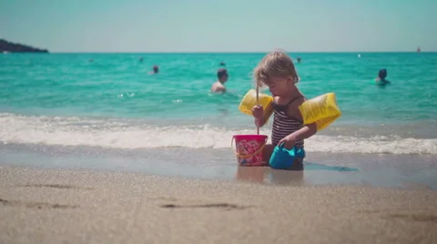 Playing with Sand and Waves on The Beach on a Summer Day Stock Footage 60383860