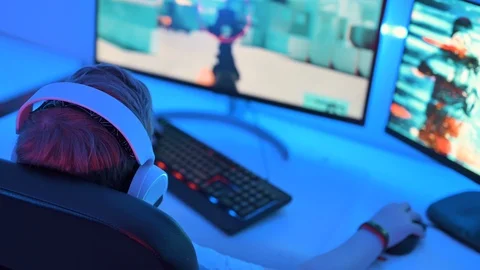 Playing shooter game online on computer at night Stock Footage 122525426