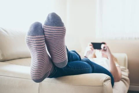 Playing with the smart phone on the sofa Stock Photos