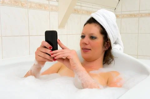 Playing with smartphone in bath Stock Photos