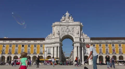 Playing with soap bubbles near Famous arch at the Praca do Comercio Видео 67891565