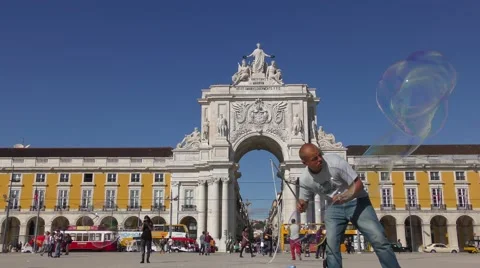 Playing with soap bubbles near Famous arch at the Praca do Comercio Видео 67891838