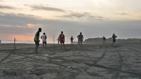 Playing soccer at the beach side with beautiful orange sunset in Bali Stock Footage 93635745