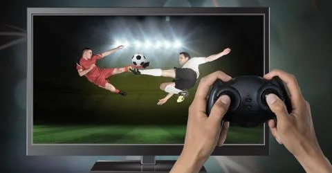 Playing soccer computer game with controller in hands Stock Photos