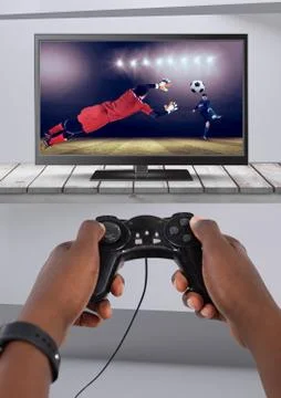 Playing soccer computer game with controller in hands Stock Photos