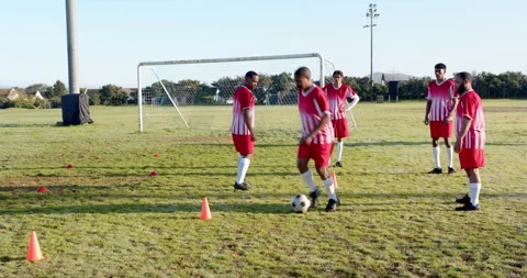 Playing soccer, team practicing drills on field with cones and goalpost Stock Footage 297343902