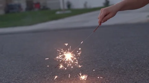 Playing with Sparkler on Ground Video stock 99457815