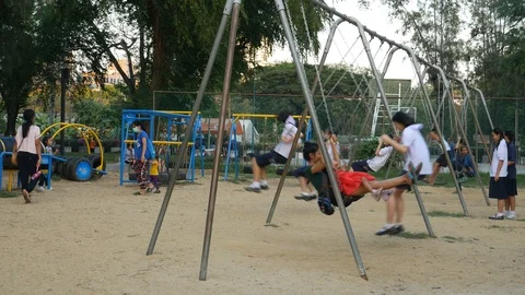 Playing swings in playground Stock-Footage 105944911
