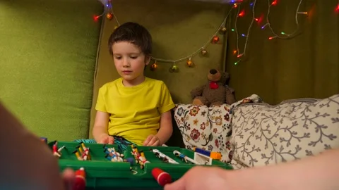 Playing table game with kid. Boy having fun with father in little playroom with Stock Footage 133511344