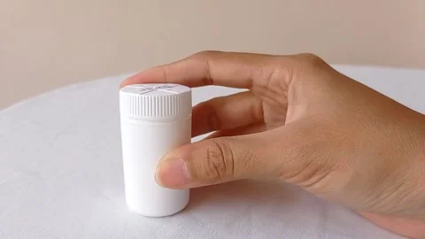 Playing with a tiny white jar on a white table Stock Footage 145562649