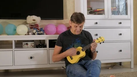 Playing ukulele selective soft focus Stock Footage 83524314