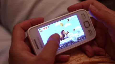 Playing video game on smartphone - editorial footage Stock Footage 137824005