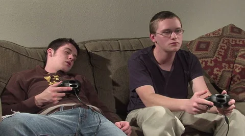 Playing video games on couch. one sleeping. Stock Footage 49862853