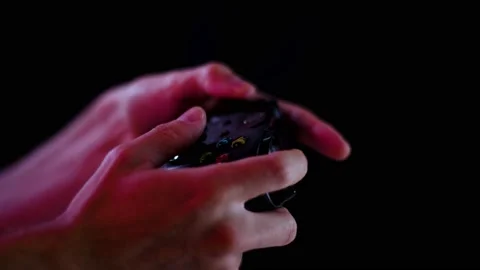 Playing video games in a darkened room with a black background close up on Stock Footage 137784368