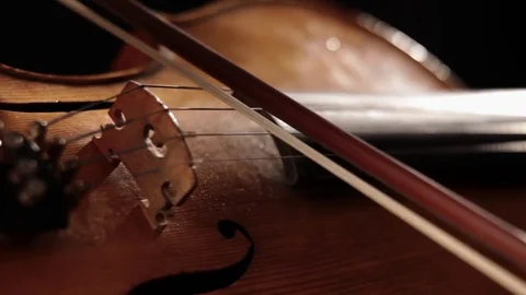 Playing Violin. Close up of violin bow going across strings Stock-Footage 82564770