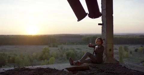 Playing violin in ruined building with sunset 4K. Stock Footage 80468311