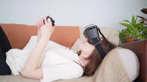 Playing virtual reality lying on the couch. Modern Scandinavian interior. New Stock Footage 149583544