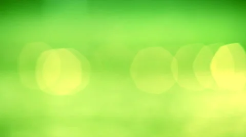 Playing yellow specks on the green background. Vibrant beams out of focus. Stock Footage 41407876