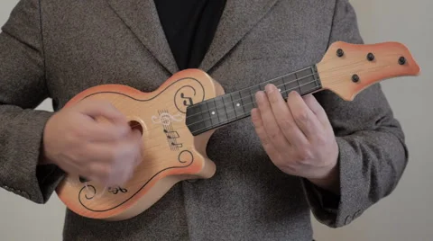 Plays in a child's guitar. Stockbeeldmateriaal 41698903