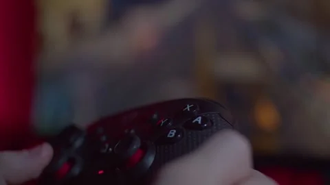 Plays a game with two hands using a gamepad Stock Footage 265176278