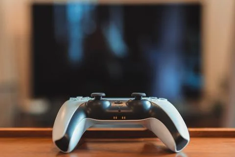 Playstation 5 (PS5) controller on the table inside a flat, selective focus. Stock Photos