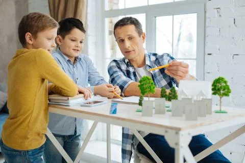 Pleasant architect explaining his landscape architecture project to sons Stock Photos