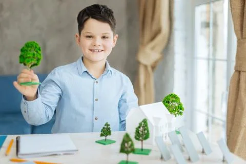 Pleasant boy posing with miniature tree models Stock Photos
