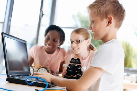 Pleasant boy watching tutorial video with his friends Stock Photos