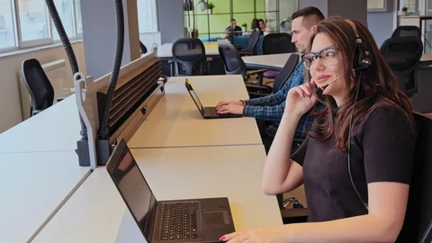 Pleasant call center operator working on laptop Stock Footage 94837734