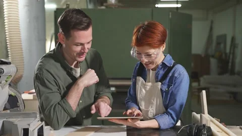 Pleasant caucasian colleagues joiners using digital tablet while working in Stock Footage 159713056