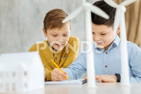 Pleasant cheerful boys drawing in the engineers office Stock Photos