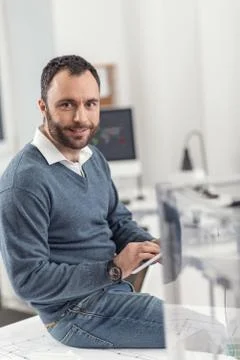 Pleasant engineer posing while controlling 3D printer via tablet 스톡 사진