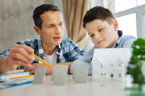 Pleasant father explaining principles of solar panels work Stock Photos