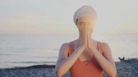 Pleasant girl of eastern appearance performs spiritual practices on the beach Stock Footage 113322112