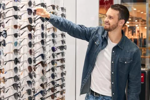 Pleasant good looking customer selecting sunglasses Stock Photos