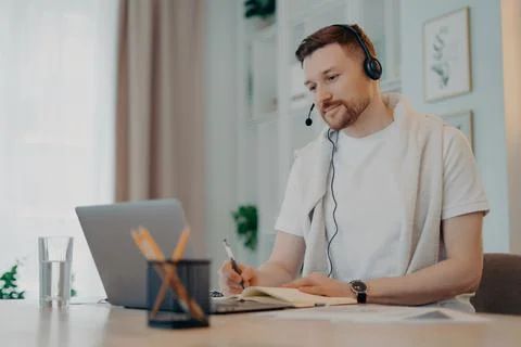 Pleasant guy in white tshirt studying at home during quarantine Foto stock