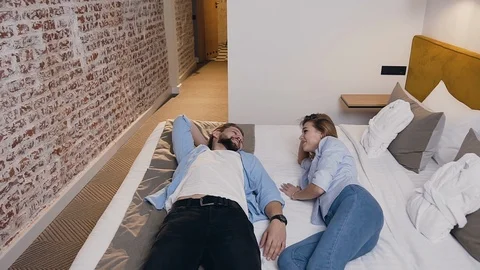 Pleasant high-spirited young amorous people resting on their hotel bed and Stock Footage 123533923