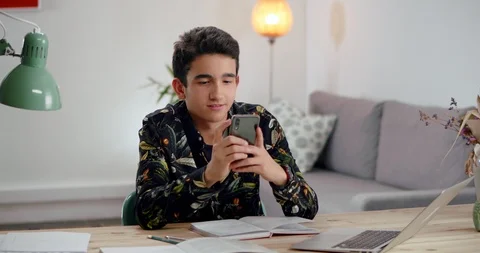Pleasant Hispanic guy showing success achievement gesture using smartphone Stock Footage 120946340