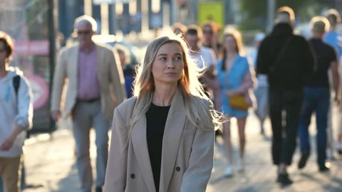 Pleasant looking blonde female person walking on streets of European downtown. Stock Footage 161311053