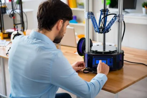Pleasant man  using 3d printer Stock Photos
