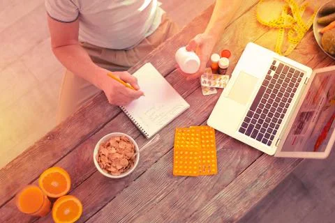 Pleasant nice man making important notes in a notebook 스톡 사진