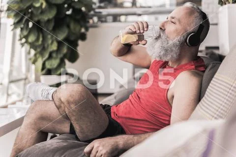 Pleasant old male is resting in athletic center Stock Photos