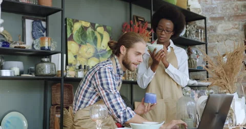 Pleasant positive hardworking mixed race male and female sellers in gift shop Stock Footage 143965351