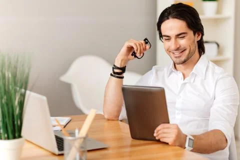 Pleasant positive man sitting at the table Stock Photos