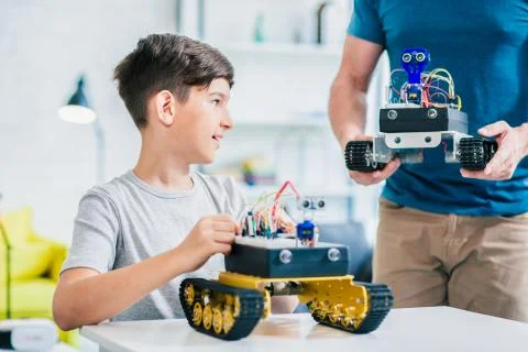 Pleasant smart boy constructing modern robotic devices Stock Photos